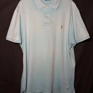 Ralph Lauren piké | Turkos/ljusblå | Slim Fit | Stl L - Läs nedan för mer info!😊  Säljer en stilren ljusblå pikétröja från Ralph Lauren med klassisk krage och knappar. Tröjan har det ikoniska broderade logotypen på bröstet. Perfekt för en avslappnad men ändå snygg look.  Produktinformation:  ✅ Märke: Ralph Lauren  ✅ Storlek: L  ✅ Färg: Turkos ✅ Material: Bomull ✅ Passform: Slim fit – perfekt att styla med jeans eller chinos. ✅ Skick: Mycket bra skick, knappt använd  Frakt och betalning: 📦 Snabb leverans – skickar inom 1-2 dagar efter beställning📦