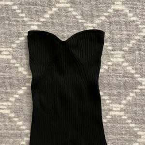 Svart ribbad tubtopp - Super fin tubtopp från Lindex som är ett perfekt bas plagg alla behöver i sommar. Toppen är ribbad och därför väldigt stretchig, storleken är XS men tror den även skulle passa på någon men S. Oanvänd och fortfarande i ny skick. Säljer för att jag inte har plats i garderoben och inte kommit till användning 💕