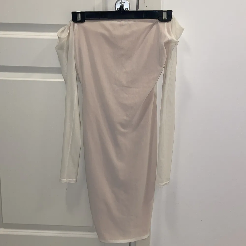 Till er som ska ta studenten, TITTA HIT!             Säljer en snygg vit klänning med beige underton från NLY One i storlek XS. Klänningen har långa ärmar och en v-ringad design med rynkdetaljer framtill. Perfekt för en stilren look! Passar även fantastiskt bra som en studentklänning. . Mekot.