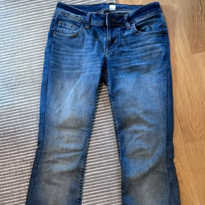 Blå lågmidjde jeans - Snygga blå lågmidjade jeans från H&M. De är sydda vid låren (kolla bild) och priset kan diskuteras💕💕💕