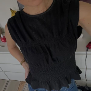 Svart smockad topp - Svart smockad topp från Vero Moda! Använd någon enstaka gång bara så av mycket gott skick!