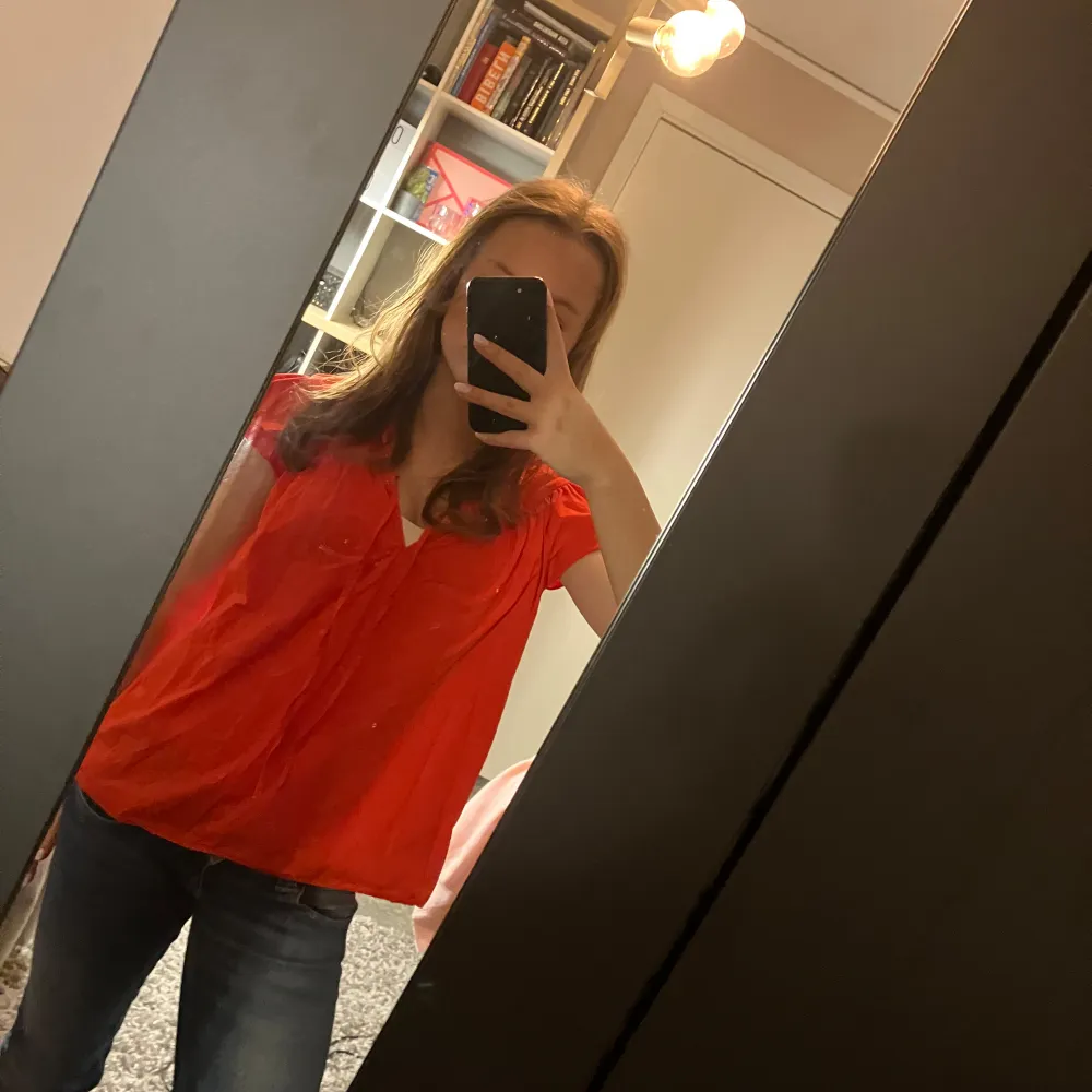 Säljer en röd blus med korta ärmar och knytband vid halsen. Perfekt för en färgglad look. Blusen har en luftig passform och är gjord i ett lätt material. 💕. Puserot.