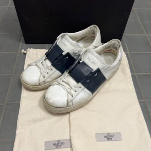 Valentino Open sneakers i vitt och blått - Snygga Valentino Open sneakers i vitt med breda blå detaljer. Skorna har klassisk snörning och är tillverkade i skinn. Perfekta för en stilren look. Kan naturligtvis tvätta dom innan jag skickar dom.