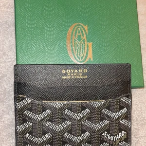 Mönstrad plånbok  - Snygg och stilren plånbok med deras ikoniska mönster i svart, vit och grå. Tillverkad i Frankrike, perfekt för att hålla dina kort och kontanter organiserade. Kommer med originalförpackning.