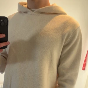 Hoodie från MNG - Säljer en stilren vit hoodie från MNG. Den är tillverkad i ett mjukt ull material och har en klassisk design med huva. Mycket bra skick är knappt använd, Storlek M