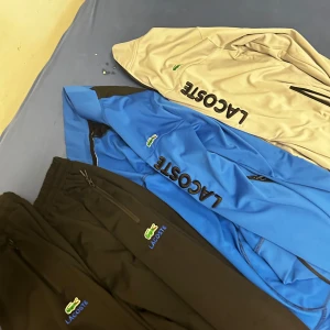 Färgglada jackor från Lacoste priset kan vi snacka om  - Säljer flera snygga jackor från Lacoste i olika färger. Jackorna har dragkedja och är långärmade med Lacoste-loggan tydligt synlig. Perfekta för en sportig look!