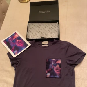 Svart t-shirt med tryck från limitato - Snygg svart t-shirt från limitato med ett färgstarkt tryck på bröstfickan. Perfekt för dig som vill ha en unik stil. T-shirten är kortärmad och har en normal passform.