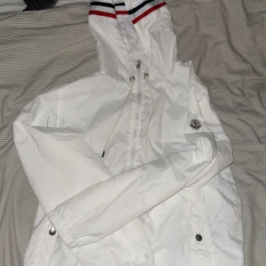 Vit vindjacka från Moncler - Säljer en stilren vit windbreaker fårn moncler!!            Den är helt ny it använd en endaste gång. Den är väldigt tunn så perfekt att ha en hoodie under nu till våren när solen börja stråla och värma!!💯 även en nfc tag har den🍾🧨