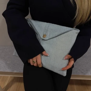 Datafodral i jeans - Unikt datafodral i ljusblått jeanstyg med guldknapp. Insidan är fodrad med ett mjukt silkestyg för extra skydd. Passar 13 tum (vanlig skoldator)