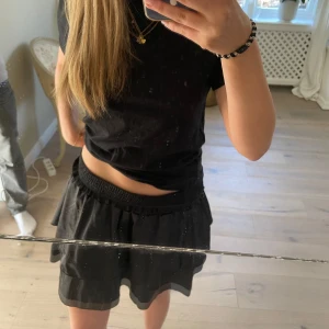 Svart kortkjol med volang - Snygg svart kortkjol med volangdetaljer. Kjolen har en elastisk midja för extra komfort. STORLEK - M/L PRIS går att diskutera! Skriv om du har frågor 🫶🤍