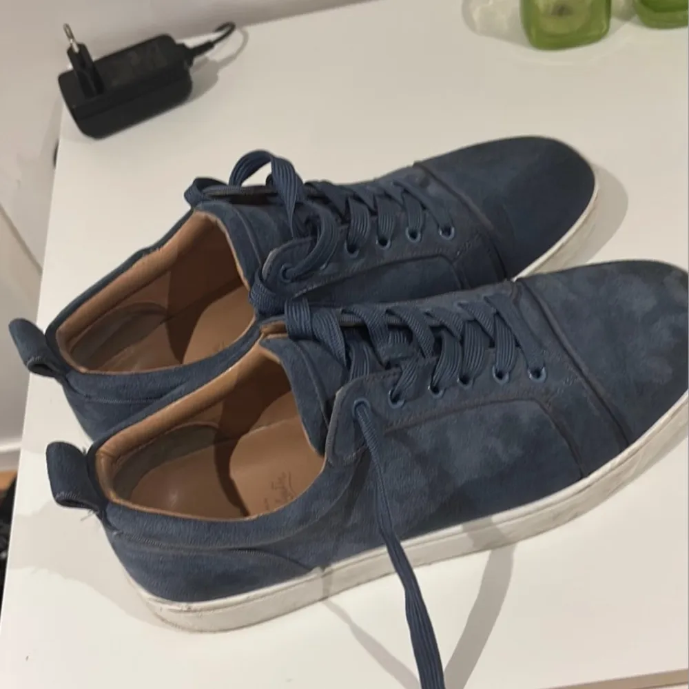 Snygga blå sneakers i mocka med en iögonfallande röd sula. Skorna har snörning och en klassisk design som passar perfekt för en stilren look. Äkta loubitins som är köpt för två år sedan i frankrike. Säljs för att jag inte använder dessa mer, använt under bröllop och större fester bara. . Kengät.