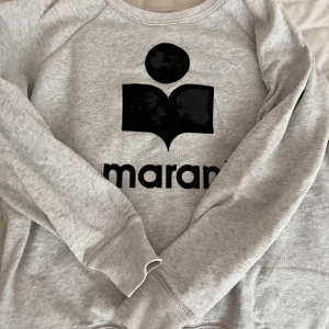 Grå sweatshirt från Isabel Marant - Säljer en stilren grå sweatshirt från Isabel Marant. Storlek S men passar på XS. lite slitage på loggan men det är inte dåligt.