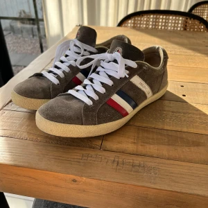 Mörkgröna sneakers från Moncler - Snygga mörkgröna sneakers från Moncler i mocka med vita snören. Skorna har Monclers ikoniska ränder i rött, vitt och blått på sidan. Är i storlek 39 men sitter något större 