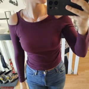 Vinröd offshoulder topp - Säljes då den är för liten för mig.Säljer en snygg vinröd topp med offshoulder-design och långa ärmar. Perfekt för en stilren look. Passar bra till jeans eller kjol.