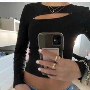 Svart ribbad topp med cut-out - Svinsnygg svart ribbad topp med lång ärm och trendig cut-out detalj vid halsen