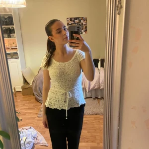 Vit spetsblus med knytband - Säljer en söt vit spetsblus med korta ärmar och knytband i midjan. Perfekt för våren och sommaren!