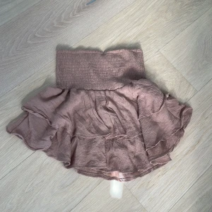 Beige volangkjol från Shein - Säljer en söt beige volangkjol från Shein. Kjolen har en elastisk midja och flera lager av volanger som ger en lekfull look. Perfekt för varma dagar och att styla med en enkel topp. Fungerar som sött sommartopp 🪷