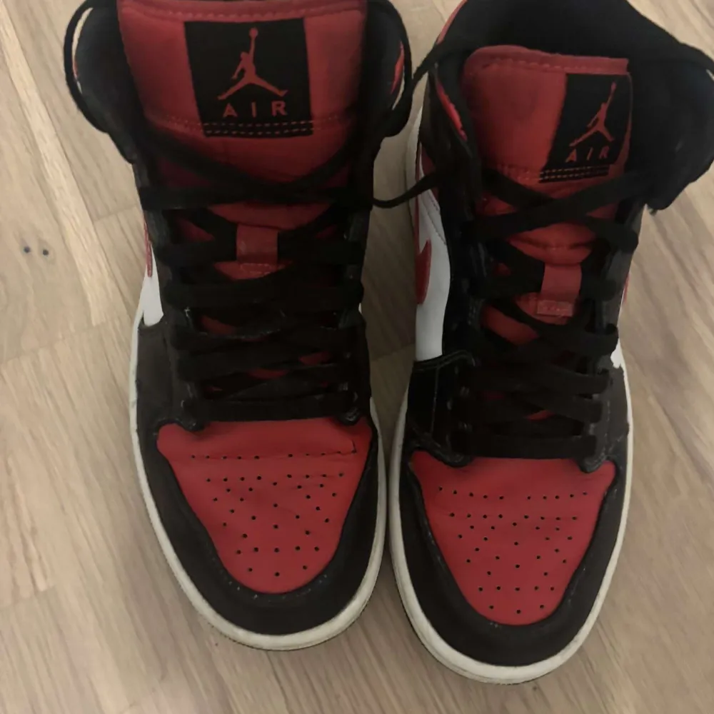 Säljer ett par klassiska Nike Air Jordans i en snygg färgkombination av rött, svart och vitt. Skorna har den ikoniska Air Jordan-loggan på sidan och snörning framtill. Perfekta för dig som vill ha en stilren och sportig look.. Kengät.