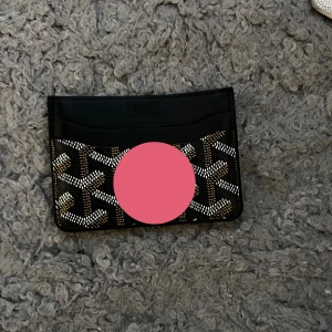 Korthållare  - Säljer ett stilrent kortfodral med rutigt mönster. Fodralet har flera fack för kort och är perfekt för dig som vill ha något smidigt och snyggt att bära med dig. Passar perfekt i fickan