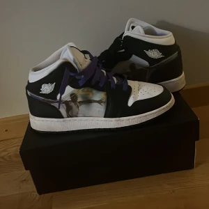 Air Jordan 1 mid - Säljer ett par Air Jordan 1 Mid (GS). Skorna är unika och har ett hologram på utsidan med två olika bilder på  Michael Jordan. Skorna är i storlek 38.5. BOX INGÅR EJ. Man fick lila och svarta skosnören och jag blandade dem sedan tappa jag bort en av dem lila och en av dem svarta skosnörena. Mycket bra skick och dem är sällan använda dem har lite ”crease”. 9/10 skick