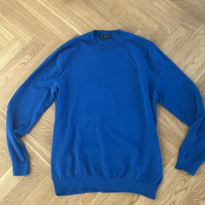 Stickad tröja Mango   - En stickad tröja från Mango i en fin blå färg, tröjan är nästintill oanvänd 