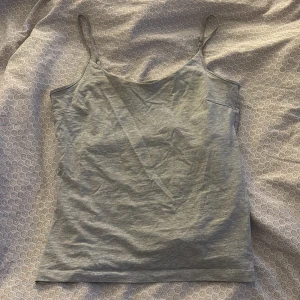 Grått linne med smala axelband från 157 - Säljer ett enkelt och stilrent grått linne från lager  157 med smala axelband. Linnet är gjort i en mjuk bomullsblandning och passar perfekt till sommaren. Färgen är ljusgrå och modellen är rak och klassisk. Finns också ett ”spänne” så man kan justera passformen om man vill  (Bild 5) 🩷Använt fåtal ggr 