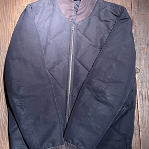 Bomberjacka från Dondup - Snygg bomberjacka från Dondup med quiltat mönster och ribbad krage. Jackan har lätt dun i sig så den passar perfekt på våren och sensommar/höst