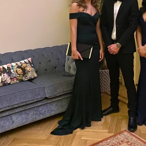 Mörkgrön offshoulder långklänning - Säljer en  mörkgrön långklänning med offshoulder-skärning och figurnära passform. Klänningen har ett långt och fint släp och markerad midja, perfekt för bal eller fest.  nypris 4000 och den är använd endast två gånger 
