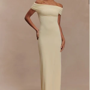 Klänning  - Säljer en elegant ljusgul långklänning med offshoulder och figurnära passform. Köptes på Meshki men returen är för dyr så bättre att sälja här! Endast testad men passade tyvärr inte. Passar S/XS. 