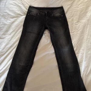 Bootleg svarta jeans med lila sömmar - Säljer ett par svarta jeans från Bootleg med lila sömmar på fickorna båda bak och fram. Dem är lågmidjade med dragkedja och knapp, samt fungerande framfickor. I gott skick förutom att sömmen längst ner är upp sprättade.