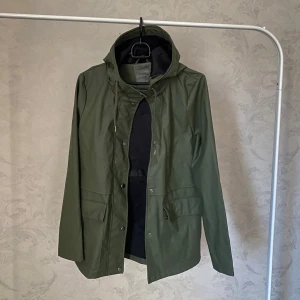 Olivgrön regnjacka med huva från ONLY - Säljer en olivgrön regnjacka från ONLY. Har i princip bara hängt i garderoben.