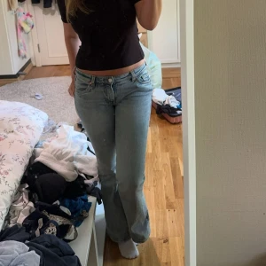 Ljus blå low waist jeans  - Midjemått: 40cm rakt över. Innebernslängd: 79cm. Jag är 168cm för referens. Jag har sprättat upp längst ner på benen så att jeansen skulle bli längre (bild 4). Jag har också sytt in utsvängingen lite där nere (bild 3) men tyget finns kvar så man kan sprätta upp till ursprunglig bredd där nere. Inga defekter förutom monki lappen vid midjan där bak, går dock att klippa bort lätt. Kommer ej ihåg storleken men skulle gissa på 36