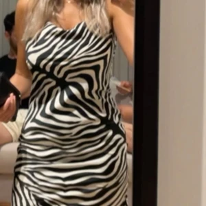 Zebramönstrad klänning från Gina Tricot - Säljer en snygg klänning från Gina Tricot med zebramönster i svart och vitt. Klänningen har smala axelband och en figurnära passform som ger en stilren look. Storlek xs