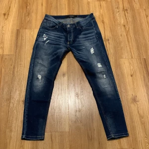 Alessandro zavetti jeans  - Snygga mörkblå jeans från Alessandro med riktigt feta slitingar och en stilren tvätt. Använda några gånger men så gott som nya. 