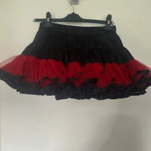 Svart och röd volangkjol med tyll onesize - Kjol med röd fluffig tyll nertill. Onesize. Resår i midjan. Helt ny. 