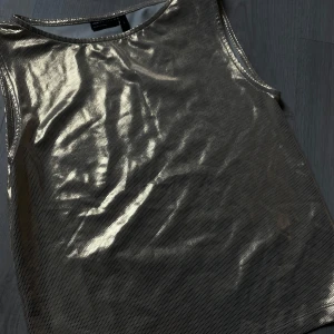 Guldig festtopp - Guldig chrome-topp. Reflekteras både guldigt och silvrigt i vissa ljus. Perfekta festtoppen (Helt oanvänd!!)🪩💿📀