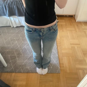 Ljusblå jeansbyxor från Gina Tricot - Säljer ett par ljusblå jeans från Gina Tricot. Byxorna har normal passform, fem fickor och bälteshällor. De är flare på modellen och har låg midja. Jag är 164cm