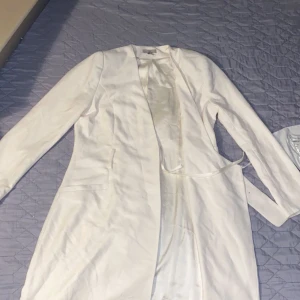 En vit/ beige kostym eller kappa  - En väldigt fin vit/ beige kostym eller kappa som är väldigt ny och sitter väldigt bekvämt 