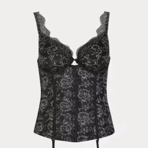 Svart spetskorsett med blommönster - Säljer en svart korsett med vackert blommönster och spetsdetaljer upptill. Modellen har bygelkupor och markerad midja för en snygg siluett. Perfekt att styla till olika outfits!