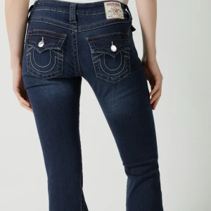 Mörkblå jeansbyxor från True Religion - Säljer ett par mörkblå jeansbyxor från True Religion. Byxorna är bootcut, de är i modellen Joey low Rise flare. De är nedlagda och passar folk i längden är 174-177! ❤️priset går att diskutera:)