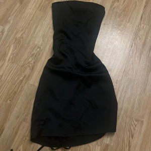 Klänning - Superfin klänning som är har en fin knytning på ryggen, lite liten i storleken och ganska kort.