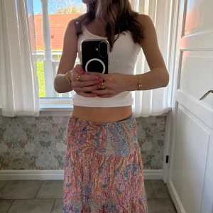 Färgglad långkjol - Säljer en superfin långkjol med färgglatt mönster i rosa, blått och orange. Den är i storlek ”teen” och då i stl xxs-s men den passar för folk med M. Jag säljer den för att den har blivit för kort för mig. Orginalpris: 499