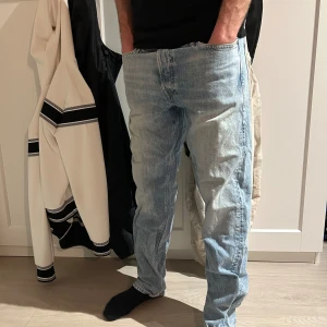 Ljusblå raka jeans - Säljer ett par klassiska ljusblå jeans med rak passform. Jeansen har fem fickor och stängs med dragkedja och knapp. Perfekta till vardags för en avslappnad stil.