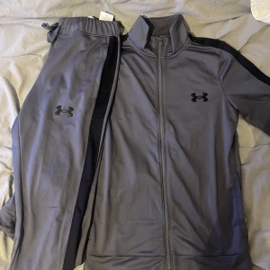 Under armour tracksuit  - Den är heeelt ny och perfekt skick tröjan sitter lite tajt på mig därför säljer jag storlek S