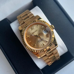 Seiko Datejust full Guld mod - Nu är denna Seiko Roman Olive Dial-mod färdigbyggd och till salu! (Custom-made.) 	•	Automatiskt NH35A-urverk 	•	Safirglas (reptåligt) 	•	Diameter: 39 mm eller 36 mm 	•	Tjocklek: 12 mm 	•	Vattentålighet: 3 ATM 	•	Material: 316L stål 	•	Genomskinlig baksida (kristall) 	•	Klocklåda & verktygskit ingår  Frågor? DM!