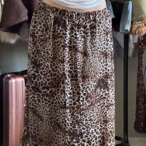 Leopardmönstrad kjol med volang - Snygg leopardmönstrad kjol från SisterS Point med volangdetaljer längst ner. Kjolen har en elastisk midja för en bekväm passform. Perfekt för att ge din outfit en vild touch 🐆 Stretchig står L på plagget men skulle säga att det mer är som en M