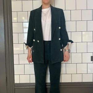 HOPE Mörkgrön kavaj  - Snygg mörkgrön kavaj i manchester från HOPE . Kavajen har en dubbelknäppt design med vita knappar och en klassisk krage.. Perfekt för en stilren look.