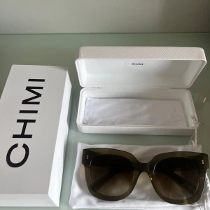 Solglasögon från Chimi 08  - Snygga solglasögon från Chimi med en stilren design. De har en fyrkantig form och en mörk tonad lins som ger ett coolt intryck. Perfekta för soliga dagar och kommer med ett praktiskt fodral för förvaring. Knappast använda. 