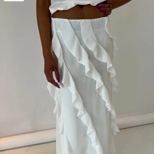 Vit långkjol med volangdetaljer - (samma bild då hela kjolen inte fick plats i en bild) Elegant vit långkjol med vackra volangdetaljer längs sidorna. Sååå fin och drömmig verkligen, men aldrig använd då den va för liten för mig💕