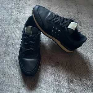 Valentino Rockrunners - Svarta rockrunners från Valentino Garavani med bitar på sidorna. Perfekt för våren, hösten och vintern. Tyvärr är en nit borta som man ser på bild 3 men går enkelt att köpa. Man får med 1-2 Grand sour om man köper före vecka 14 är slut.  Storlek 41 men passar 42 och 40
